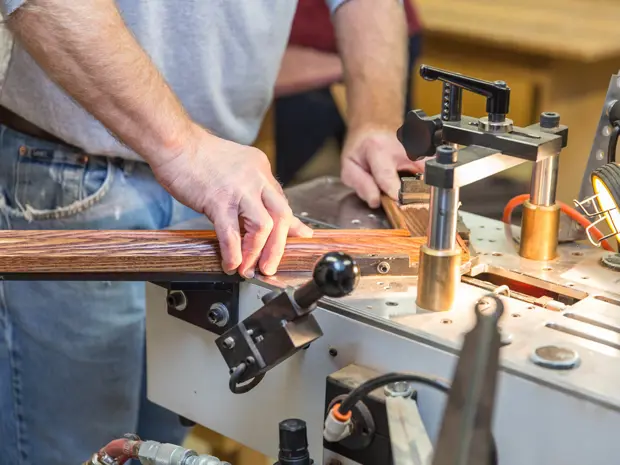 Close-up of hands working on constructing a frame for a composite. 