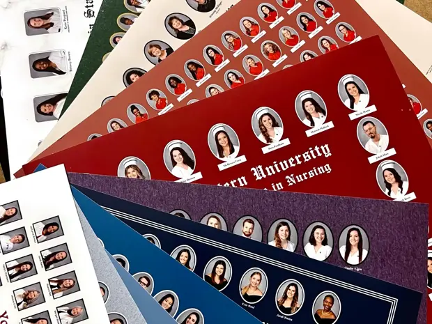 Display of printed copies of graduate and nursing composites in various colors. 