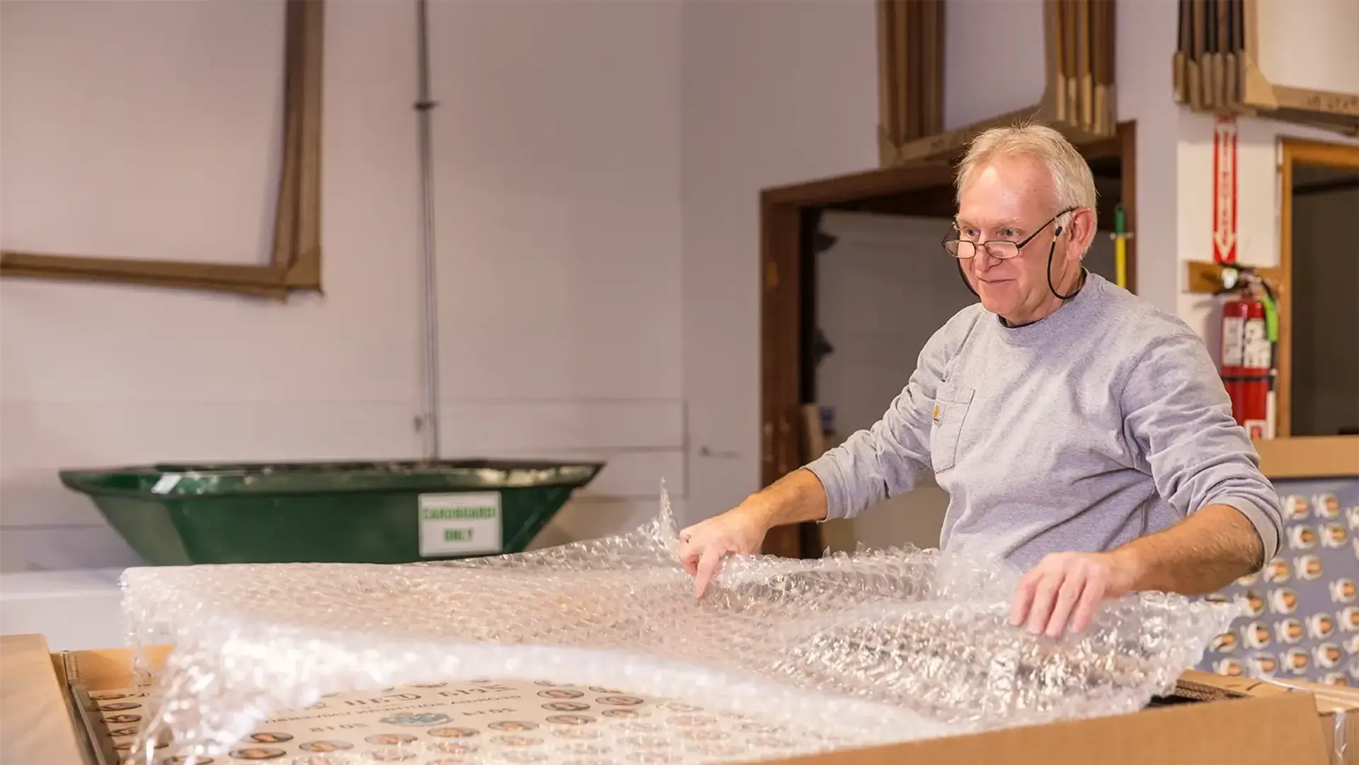 A Digital Pix team member carefully wrapping a finished composite in bubble wrap for shipping at the McHenry, Illinois production facility. 