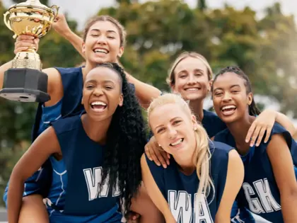Team of players celebrating a win with a trophy.  